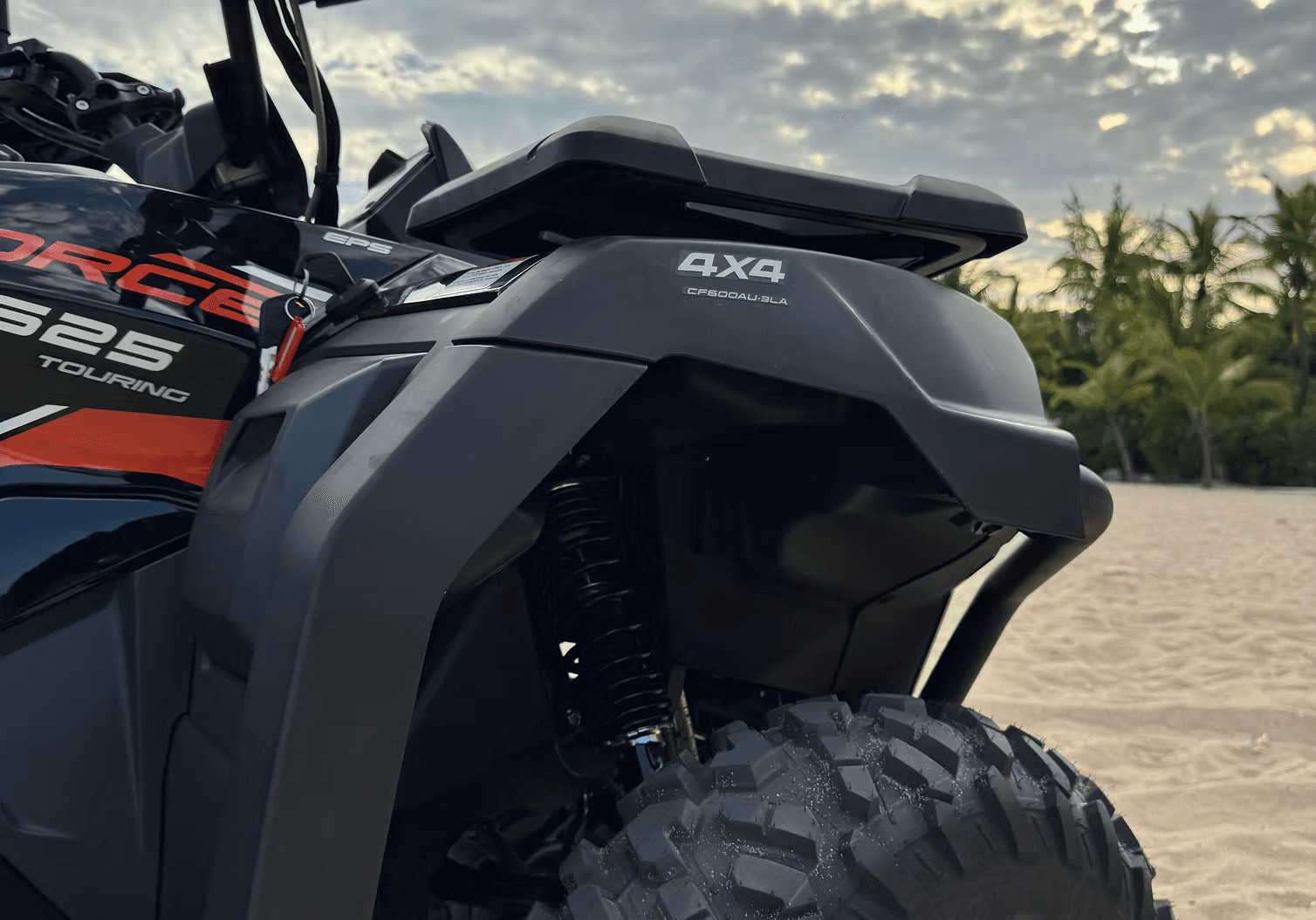 Quadriciclo vermelho na praia ao pôr do sol